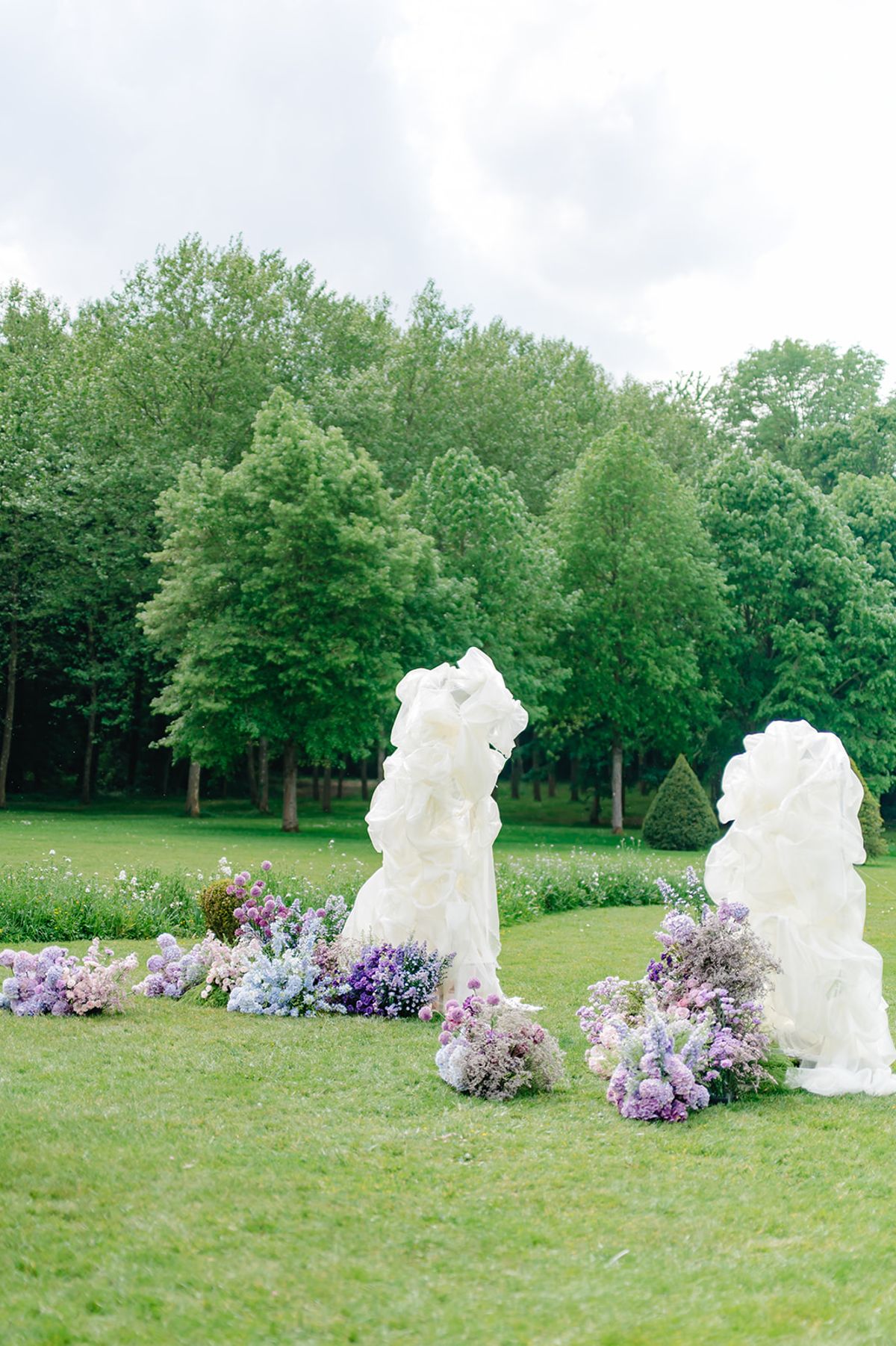 The floral arch installation against the garden greenery, before guests arrive
