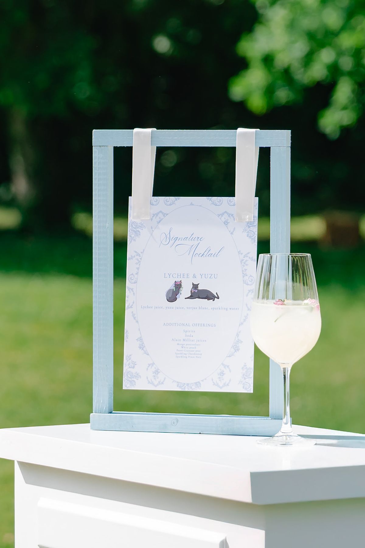 Welcome sign and menu displayed beside a glass of wine