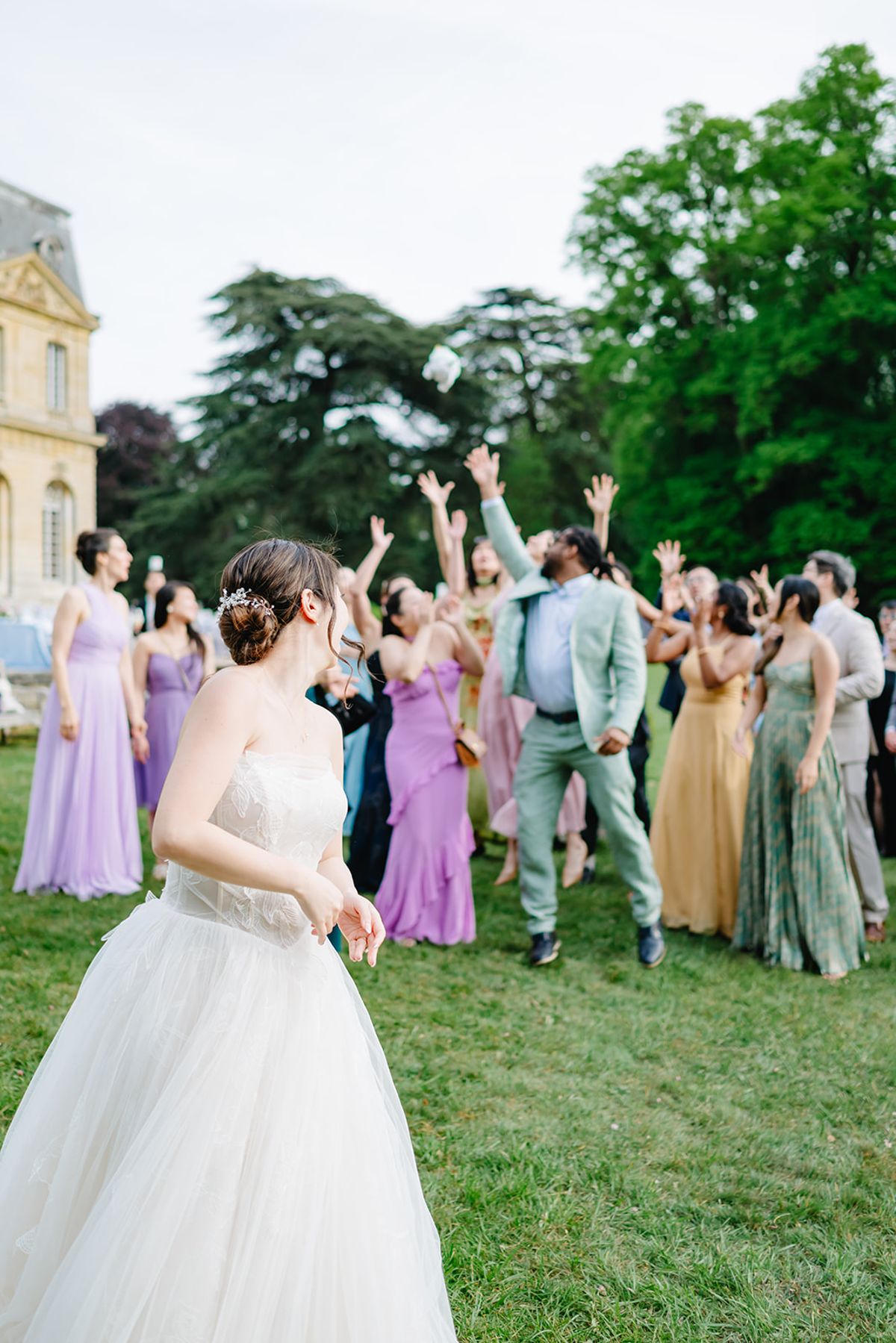 Bridesmaids in lilac dresses cheering with their bouquets raised