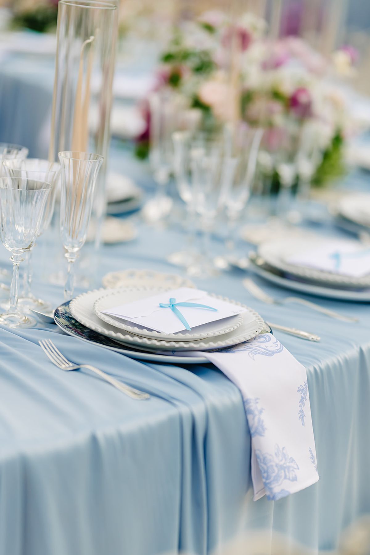 Table place setting in blue and white with a monogrammed napkin tag