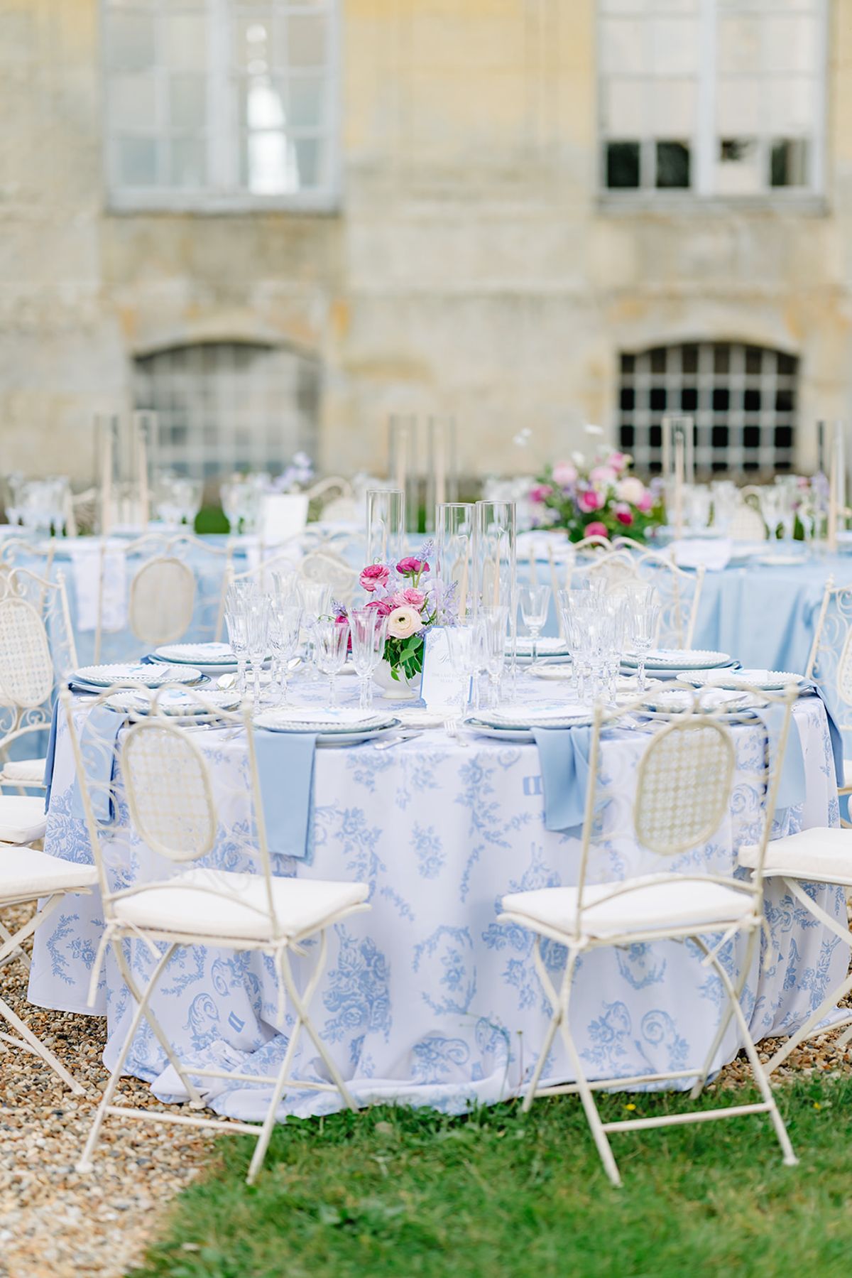 Close view of a reception table set with blue linens and pink florals