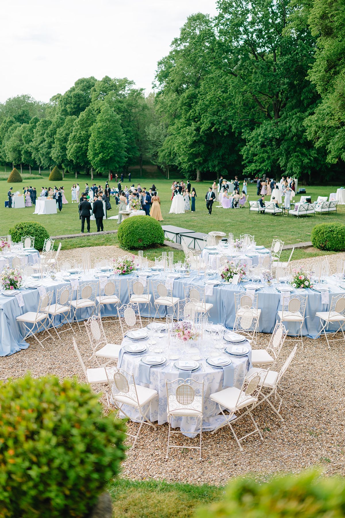 Guests seated at the outdoor reception tables in front of Château de Champlâtreux