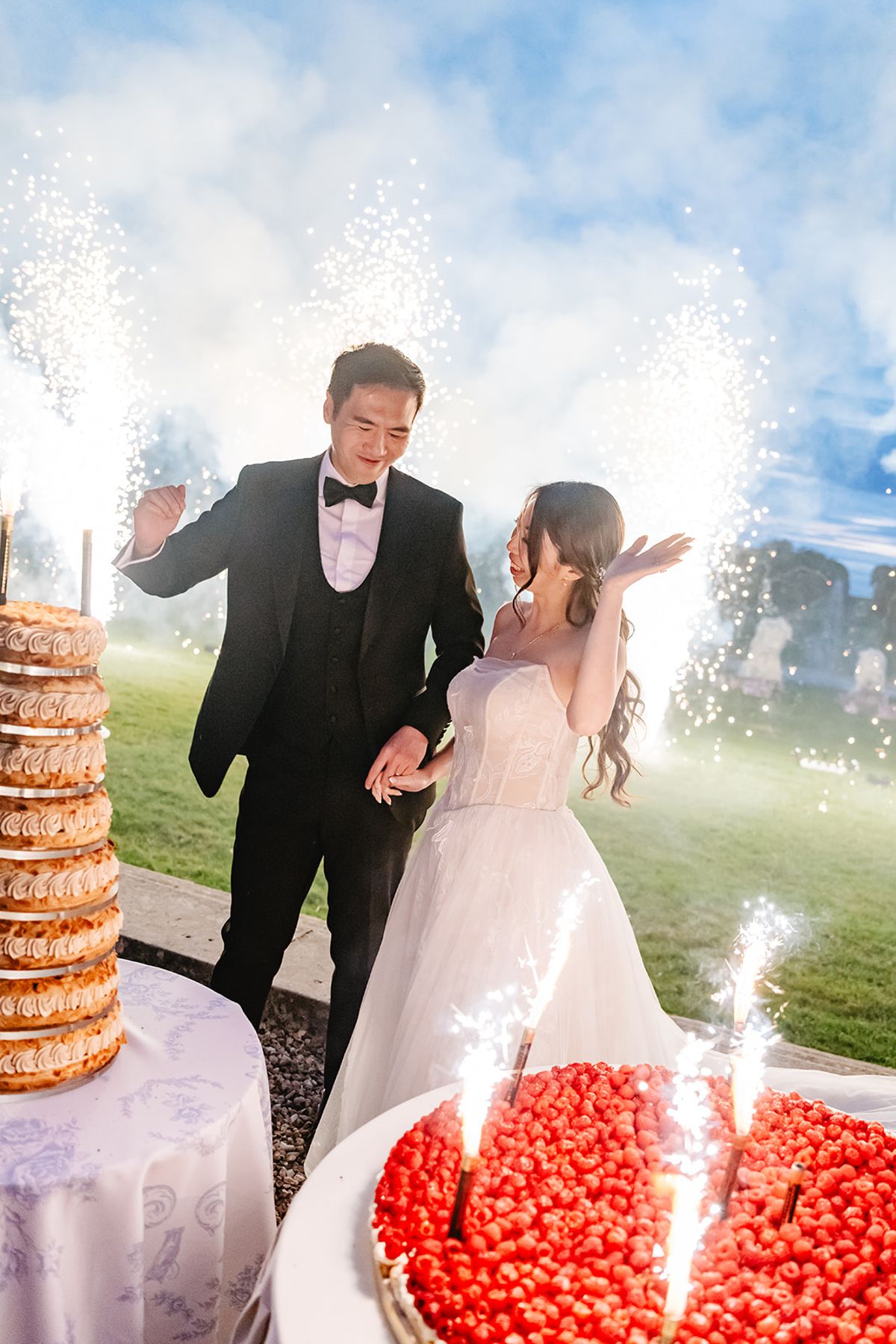 Liana and Ruiji sharing a playful moment beside the cake near the fountain