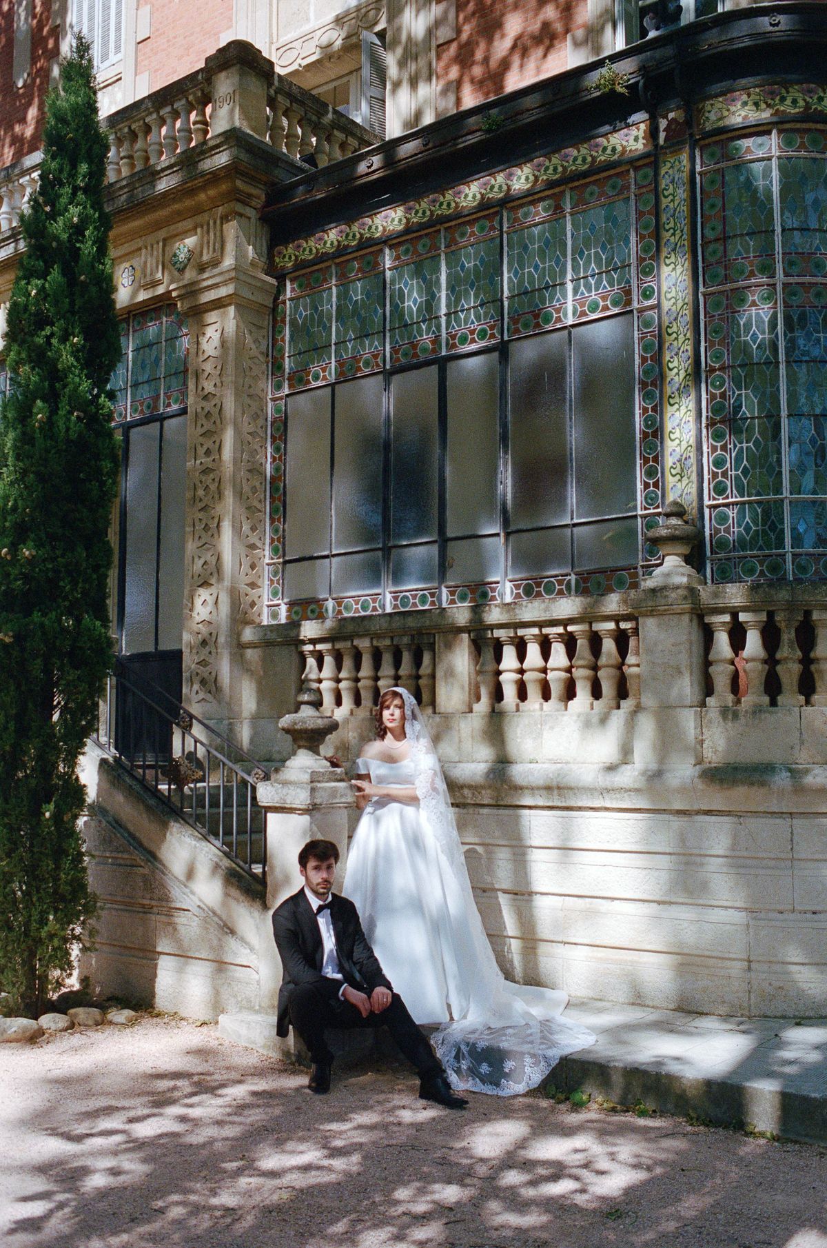 Bride and groom descending a grand stone staircase together at the chateau
