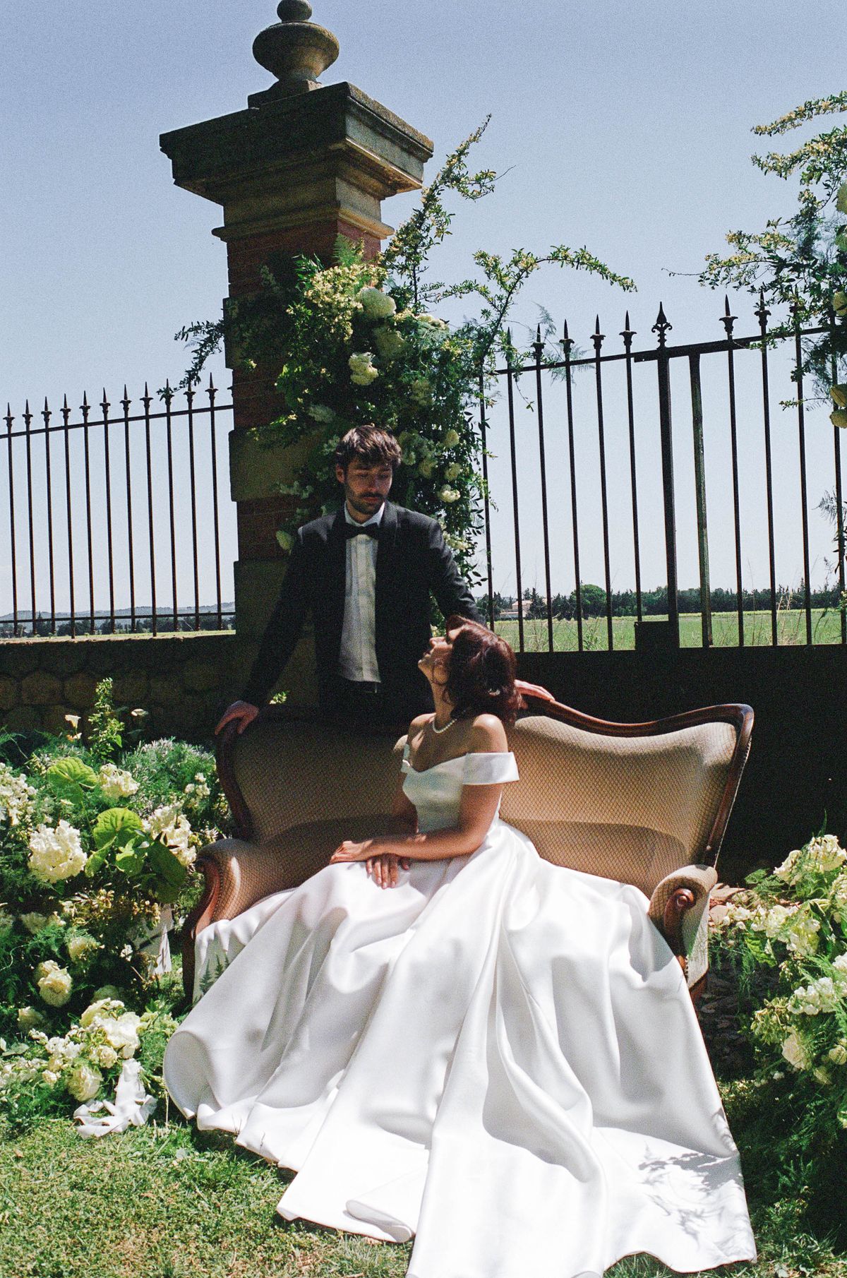 Black-and-white image of the couple standing at the altar beneath the arch, guests' benches either side