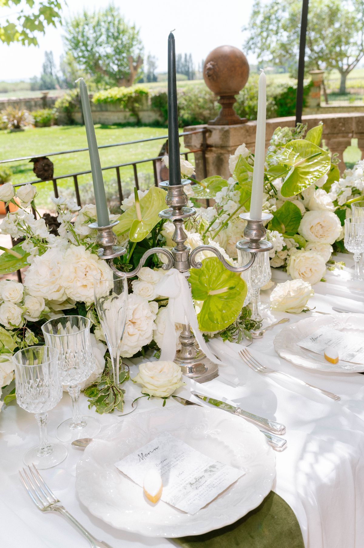 Reception place setting with candelabra, white roses and crystal glassware