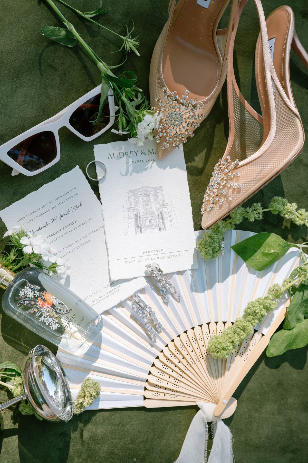 Sunglasses, invitation and folding fan styled on a woven tray