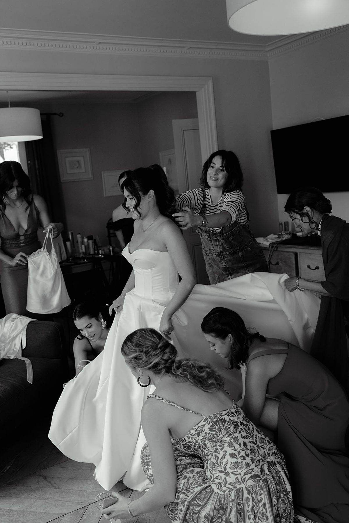 The bride being helped into her gown by her bridesmaids