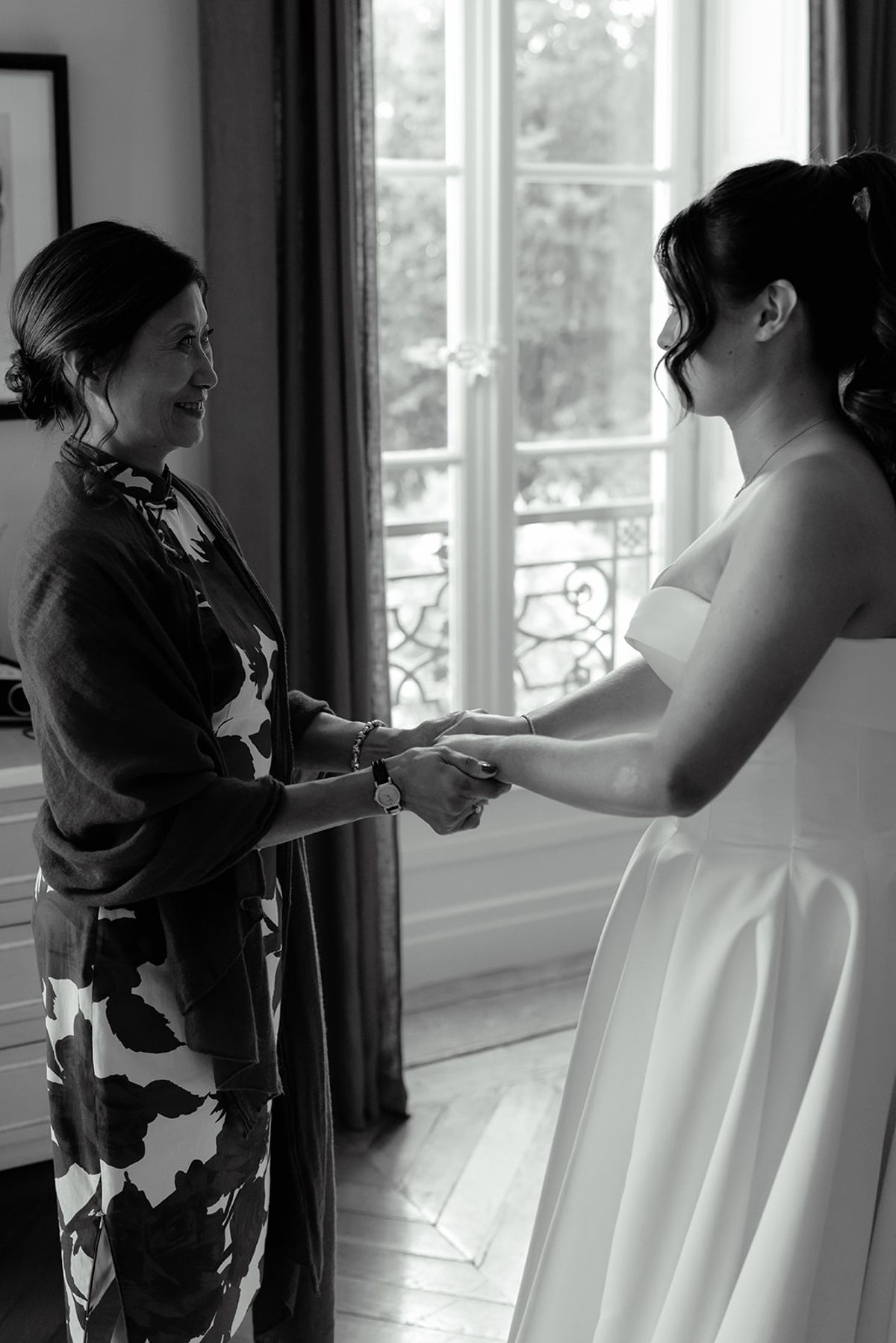 The bride at the window in the last quiet moment before the day begins