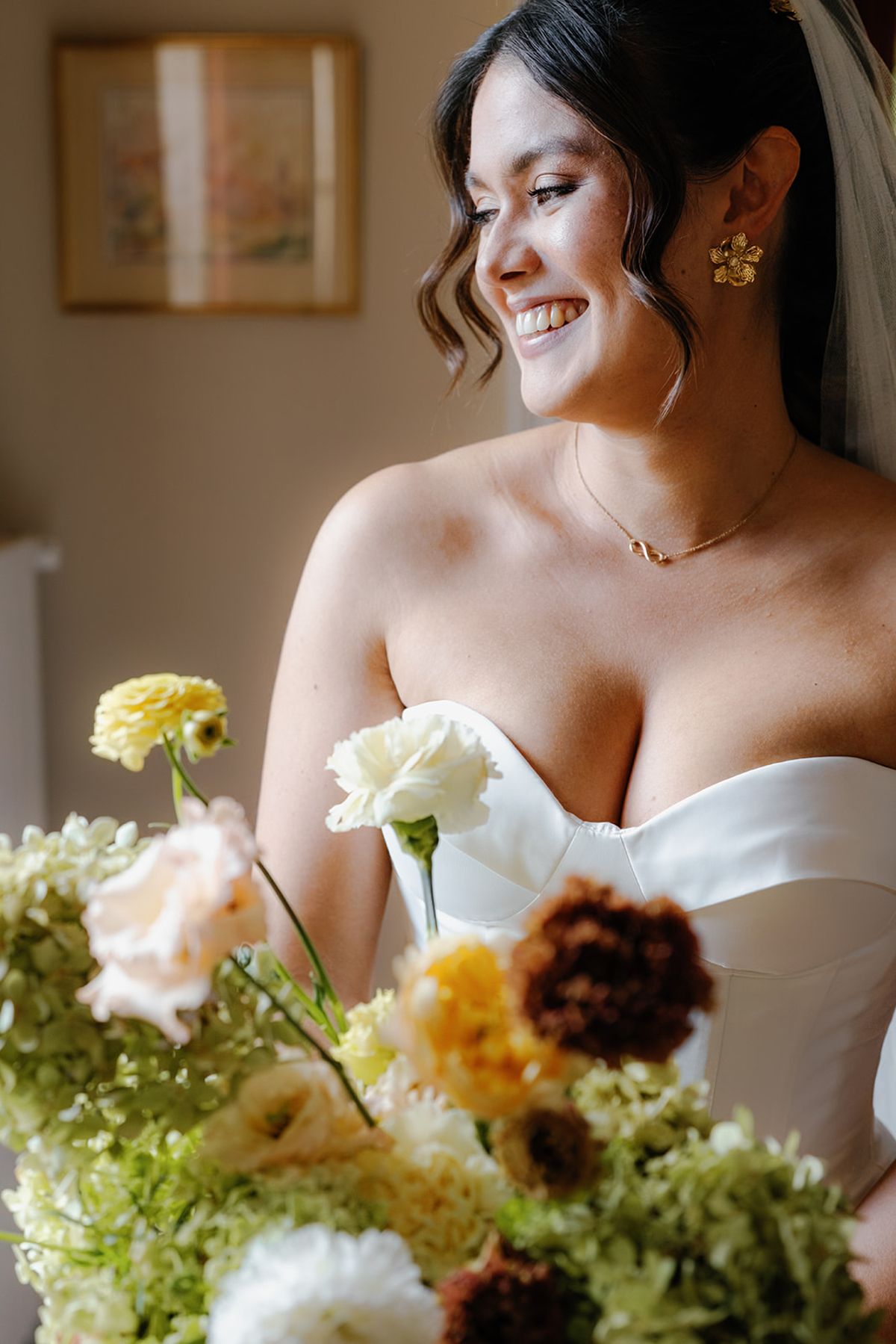 The bride photographed behind a spray of autumn flowers
