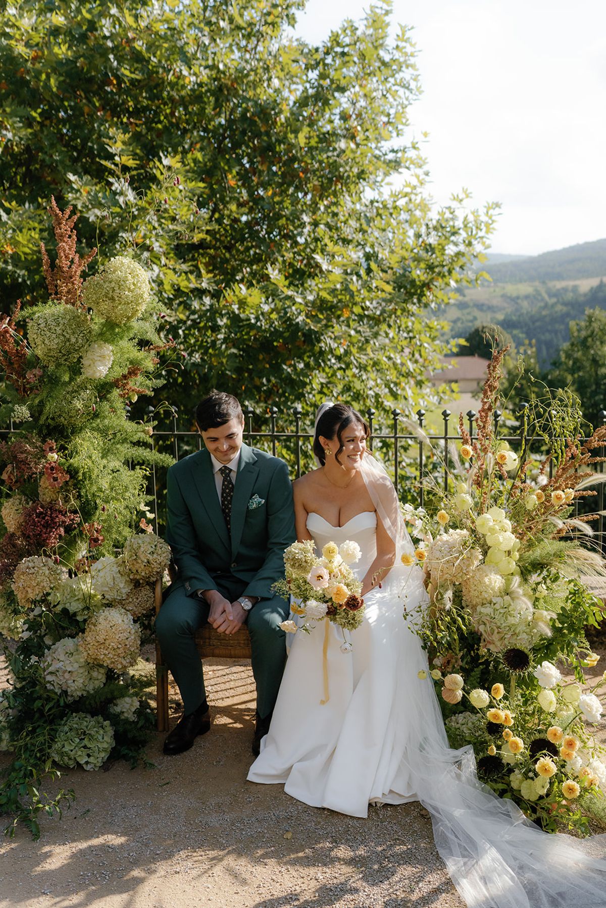The couple during the ceremony, framed by garden florals