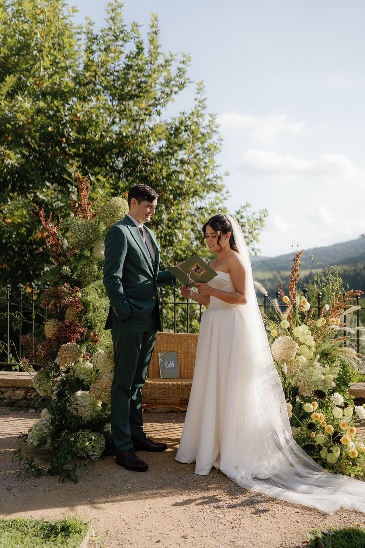 Claire and Baptiste together after the ceremony with the hills behind them