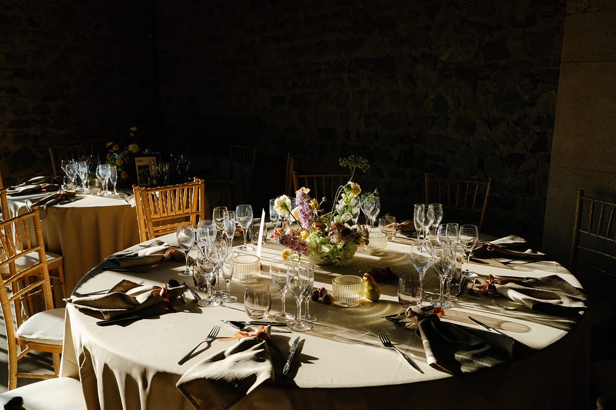 A round table laid for dinner in candlelight