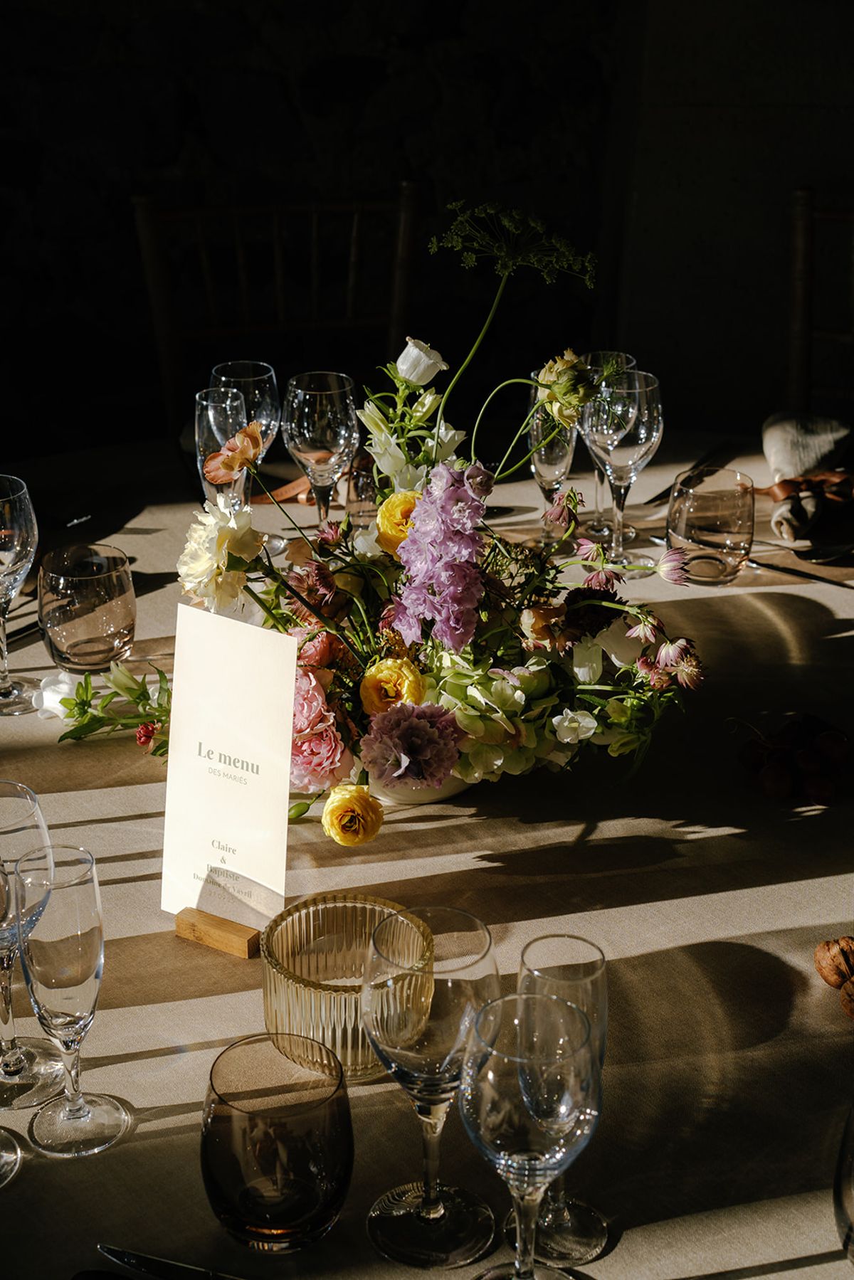 A menu card set among the table flowers