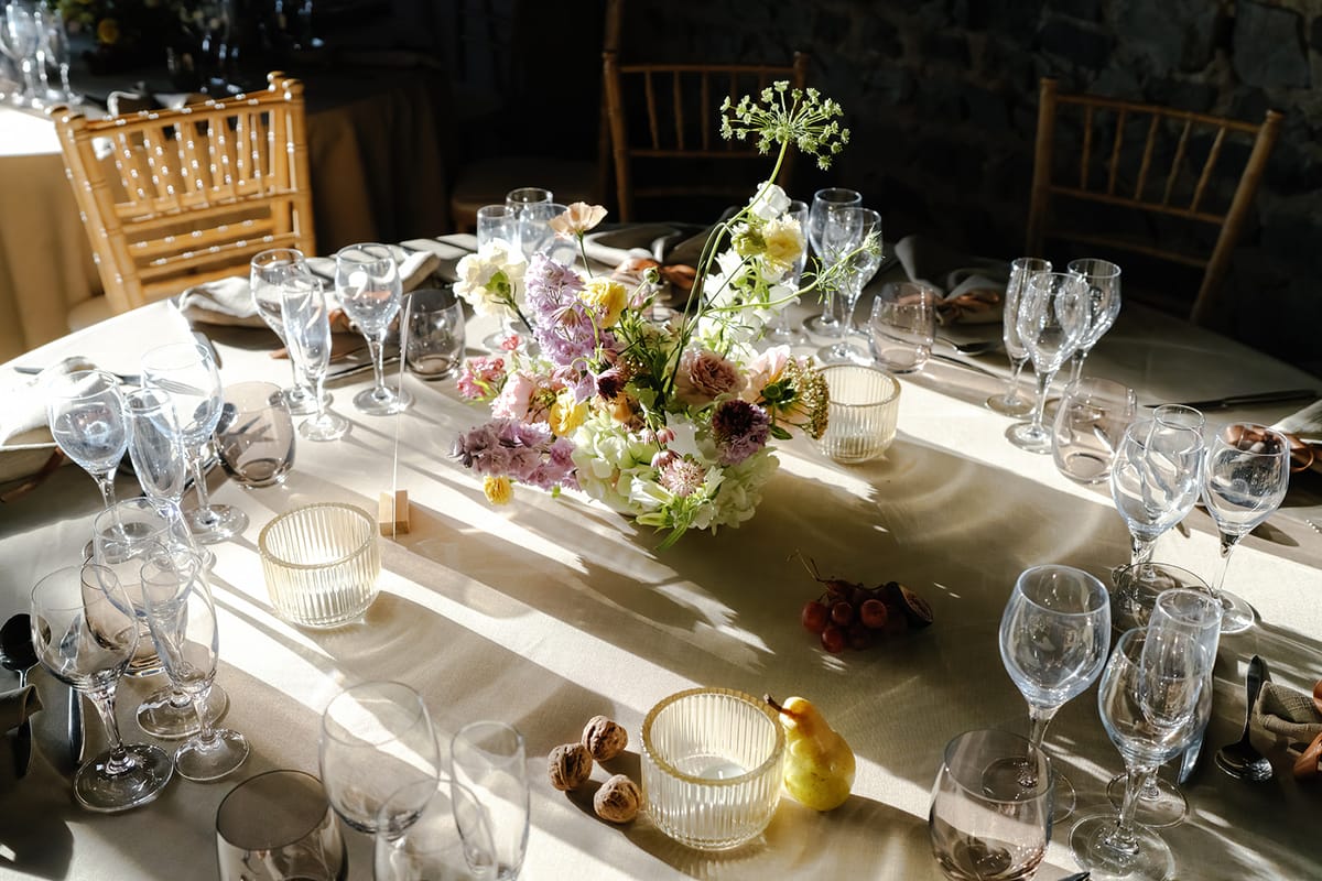 The dinner table seen from above with glassware and blooms