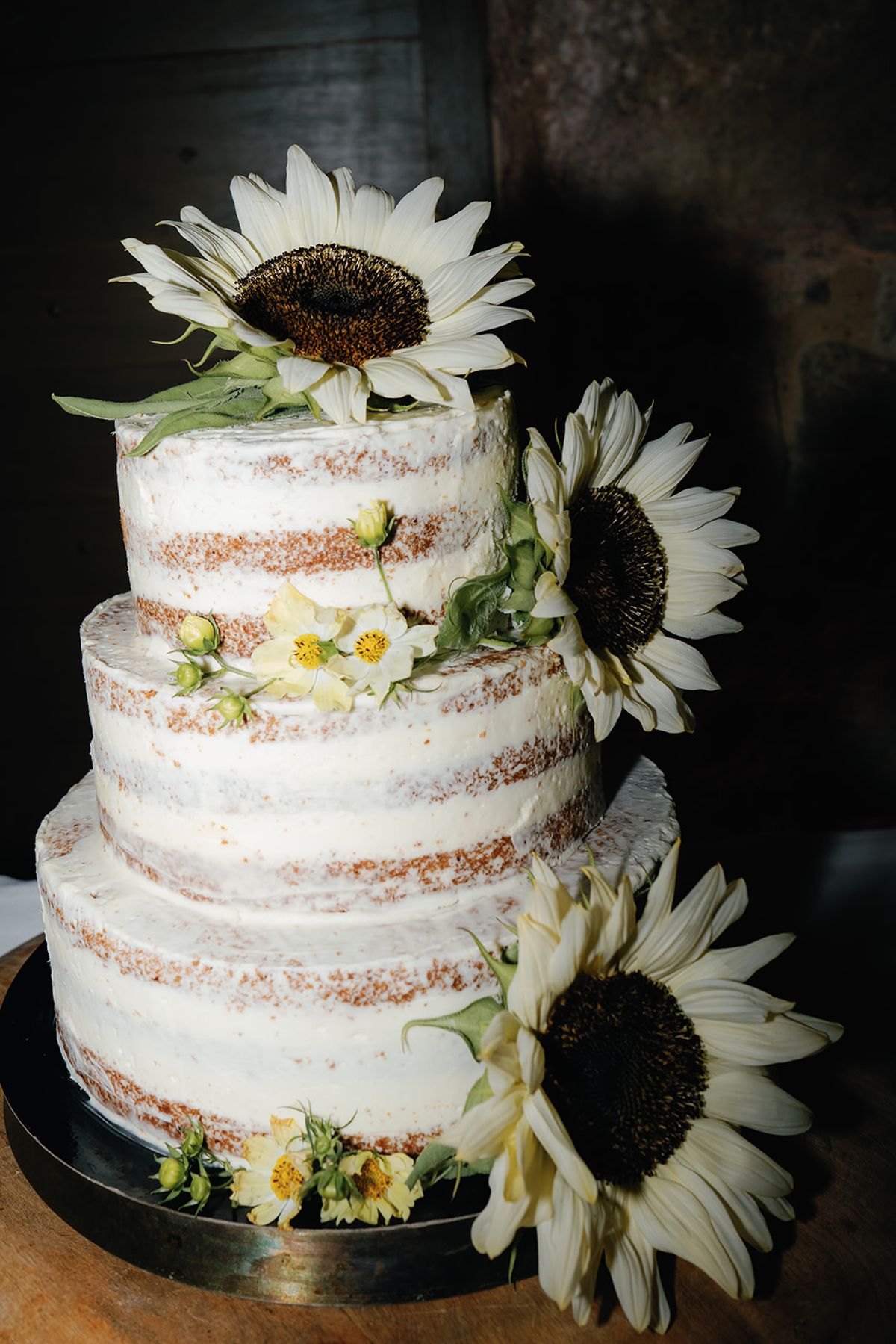 The naked wedding cake dressed with sunflowers