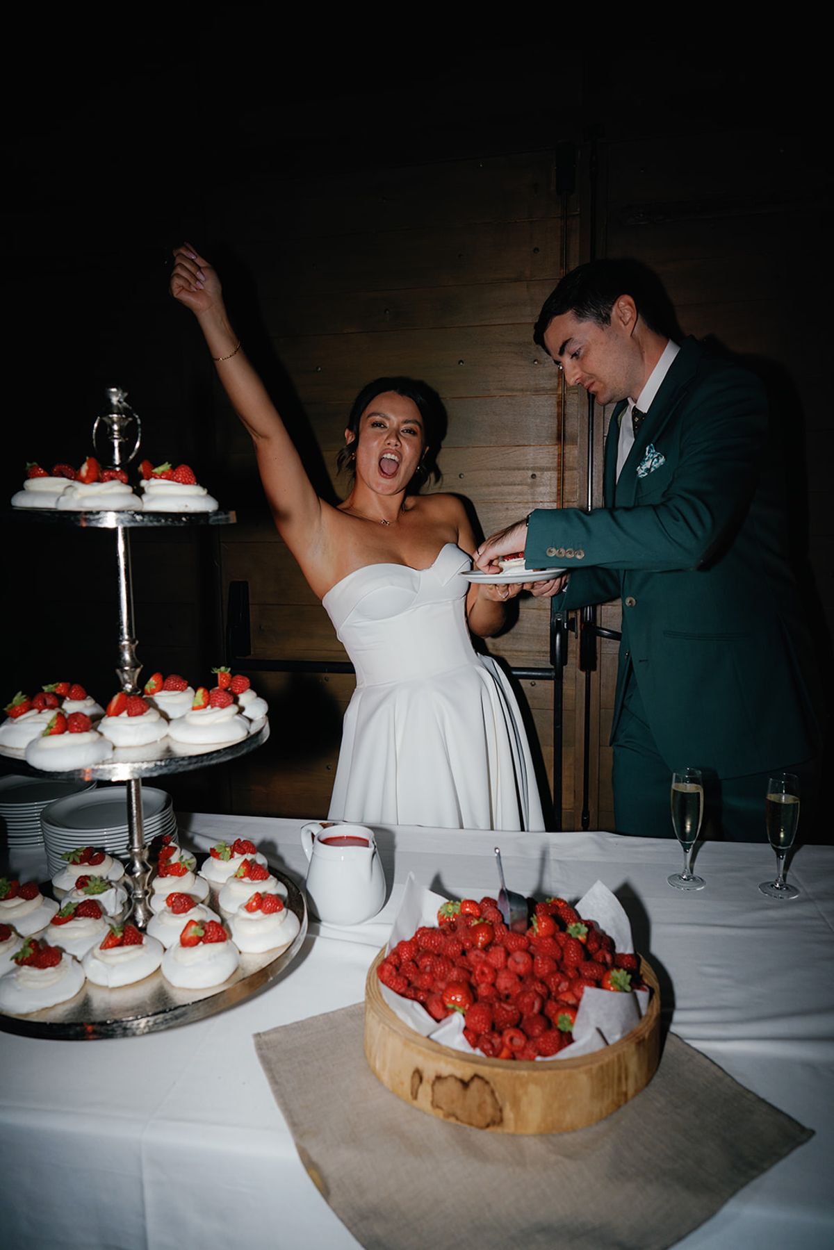 The couple cutting the cake to cheers from their guests