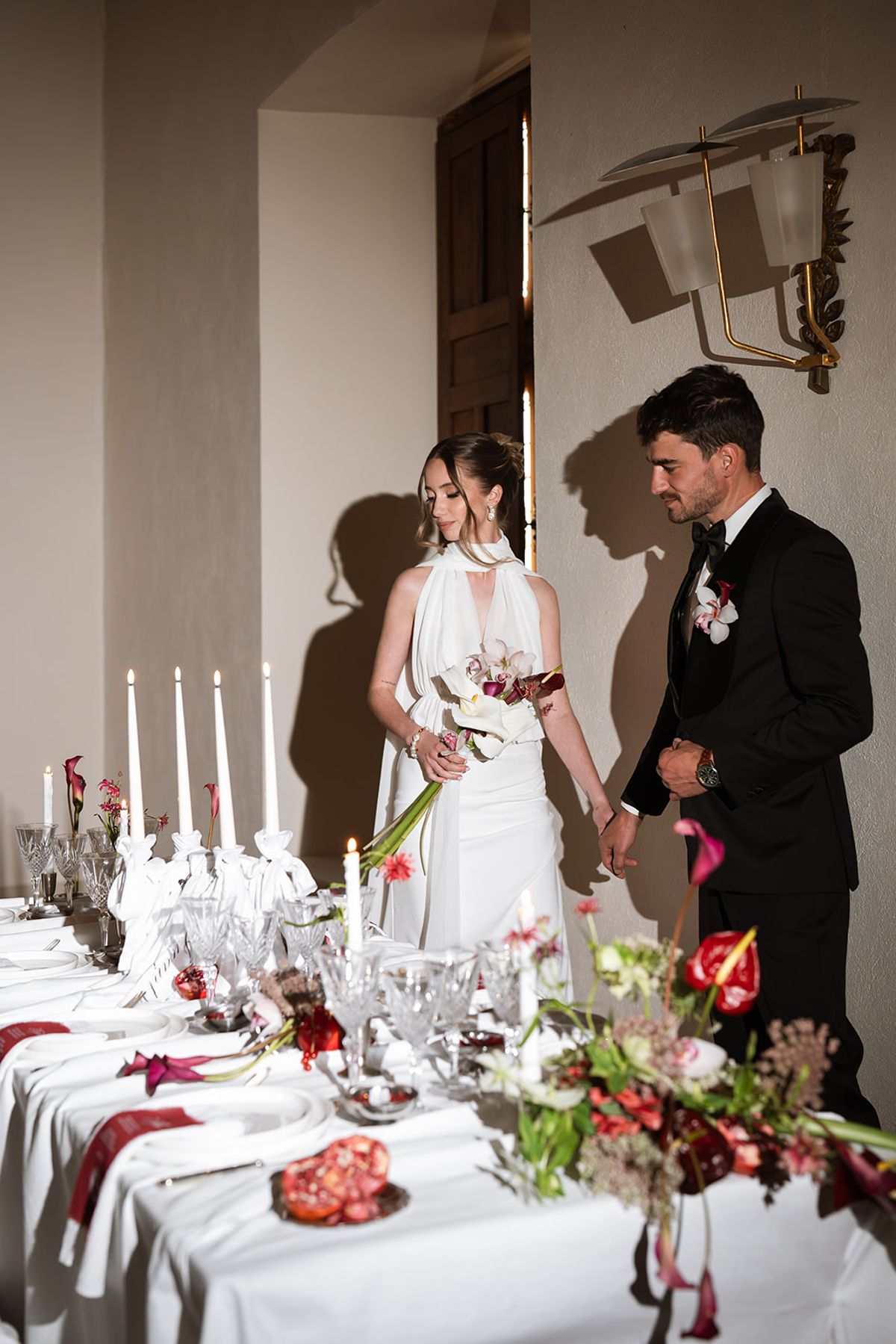 Bride and groom walking beside a candlelit tablescape at Château de Savignac-Mona