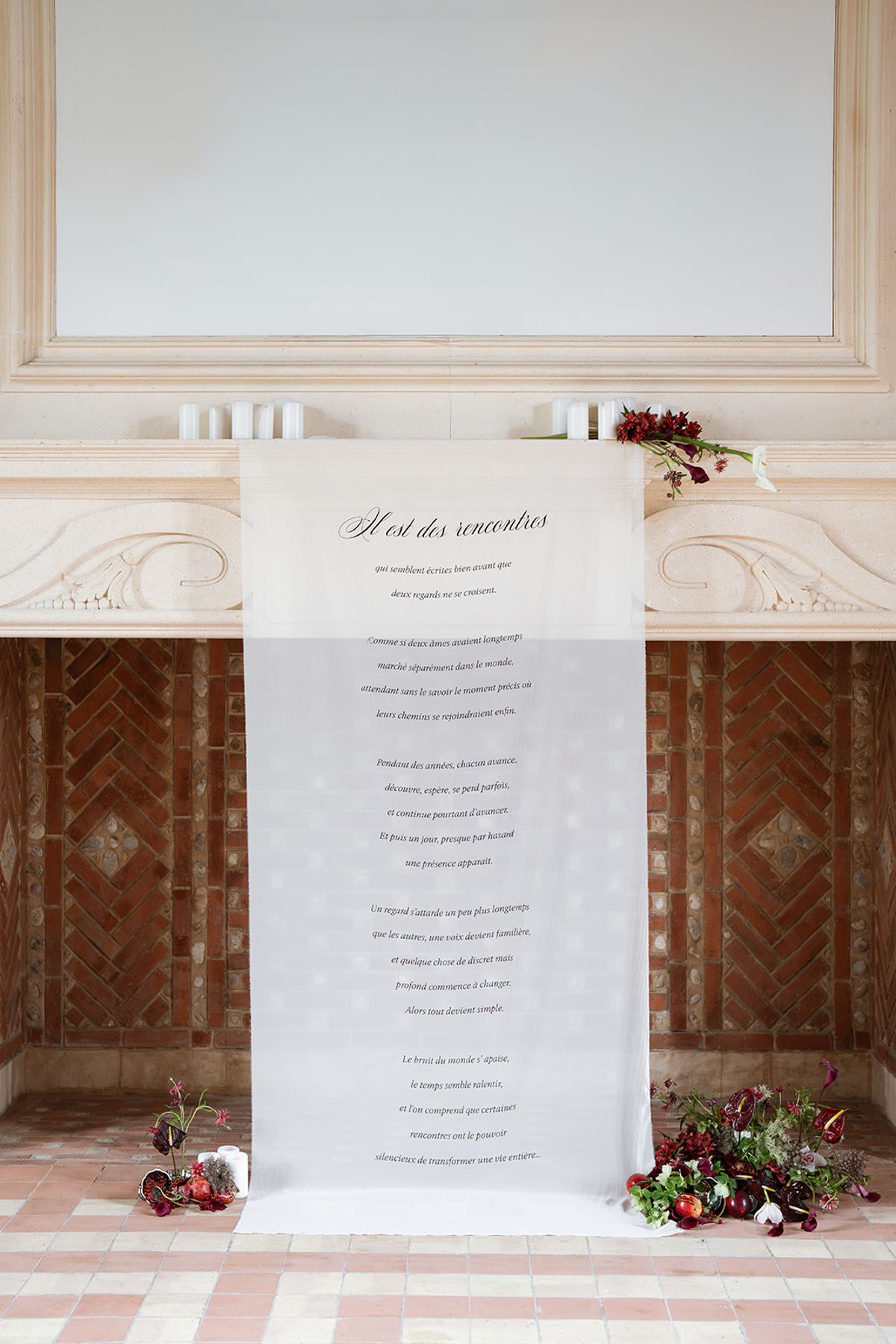 Ceremony backdrop with a printed love letter and burgundy flowers on the floor