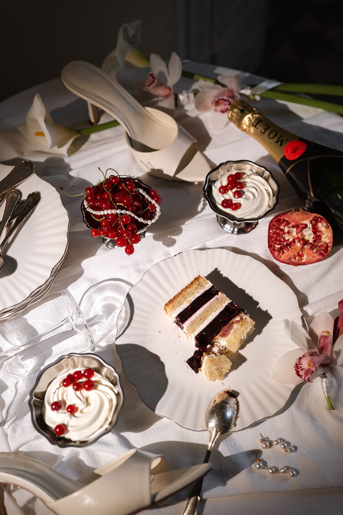 Table of cake slices, pomegranate desserts and bridal shoes