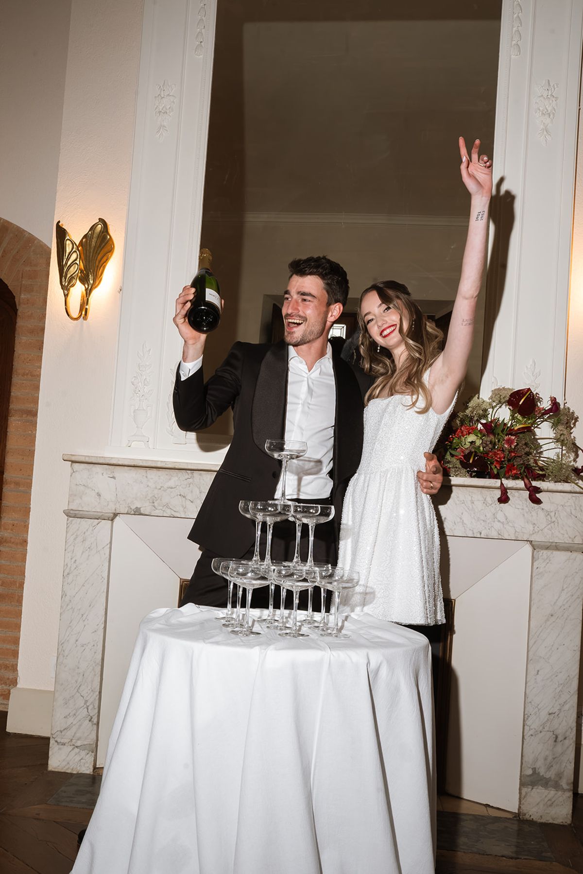 Bride and groom celebrating beside the champagne tower
