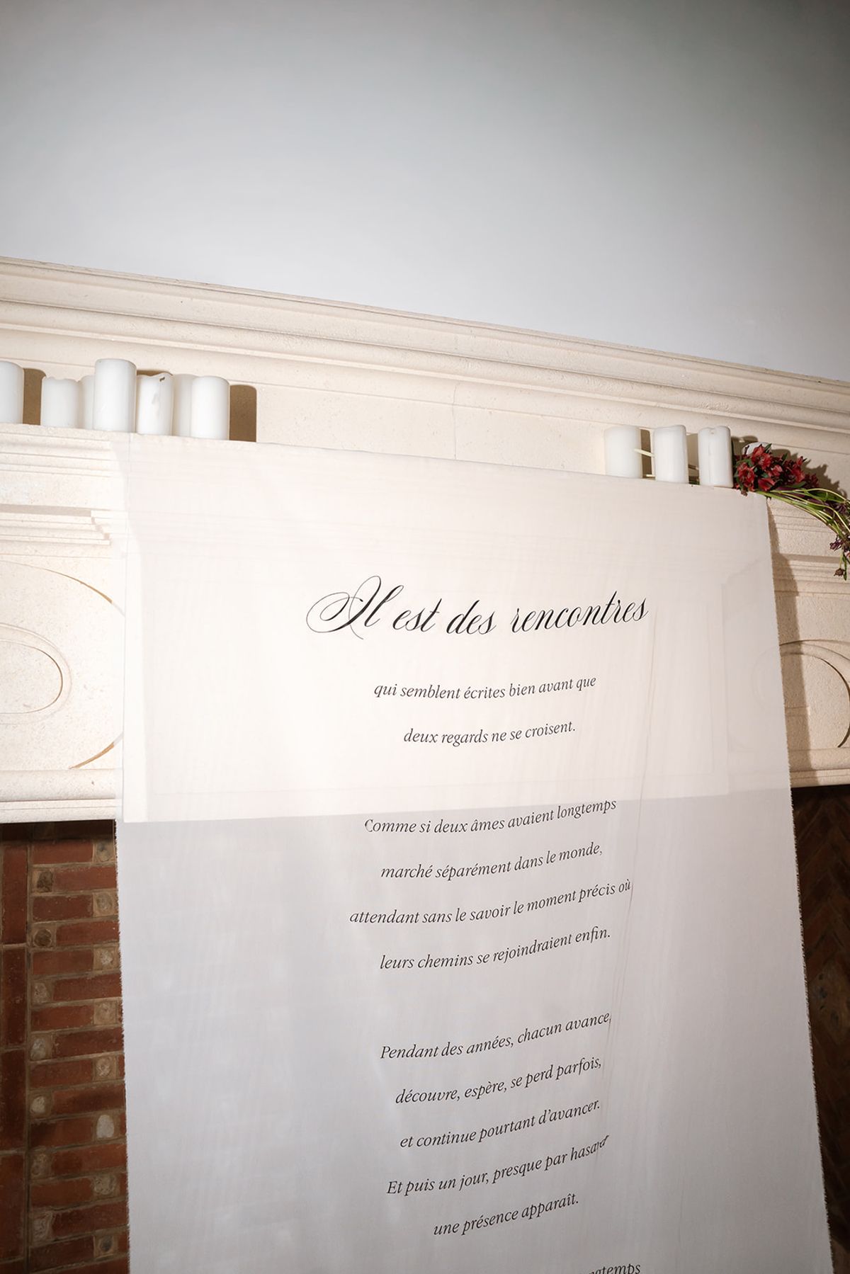 Ceremony backdrop printed with a French love letter above the fireplace
