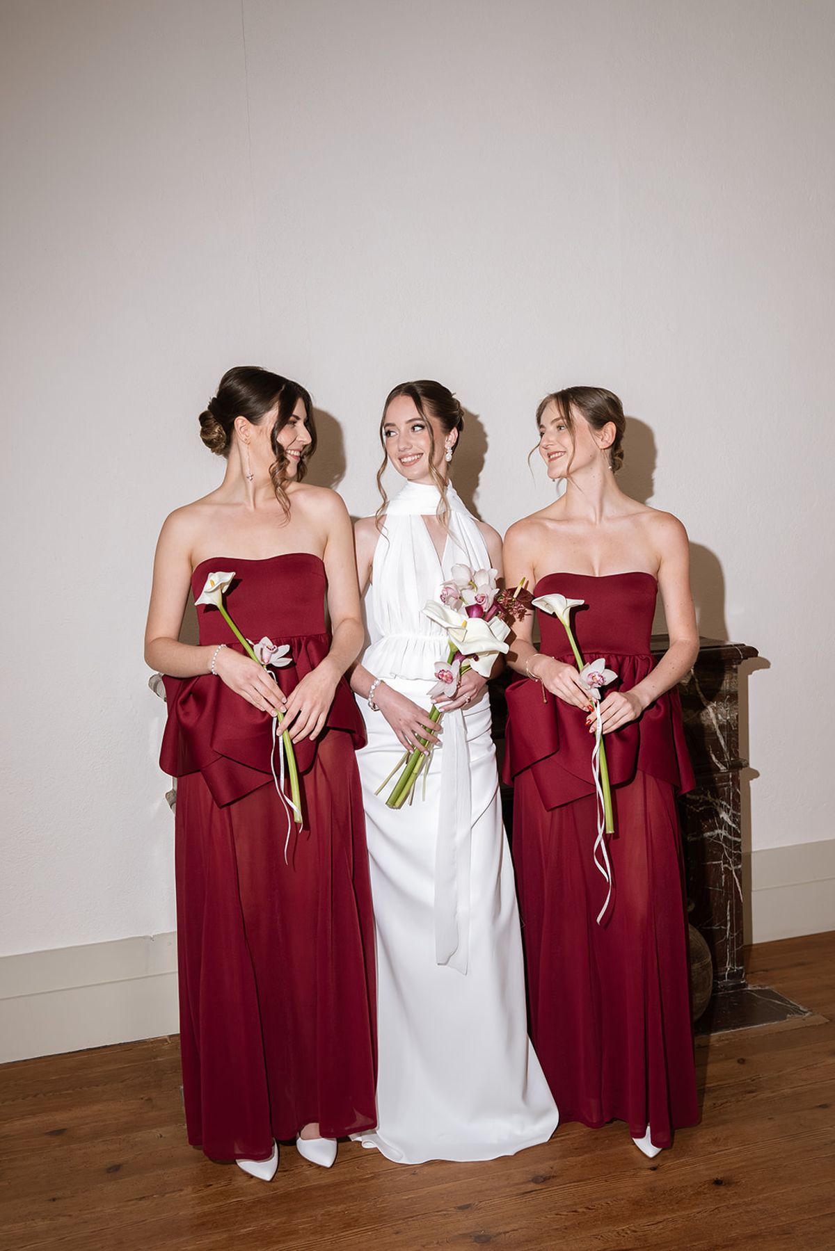 Bride with her two bridesmaids in burgundy gowns