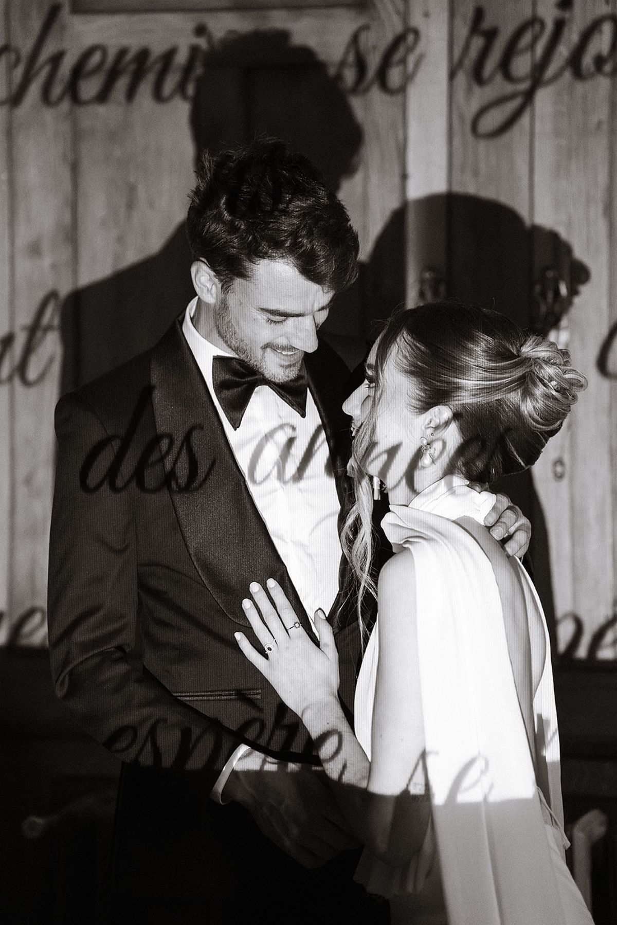 Black and white portrait of the bride and groom before a projected love letter
