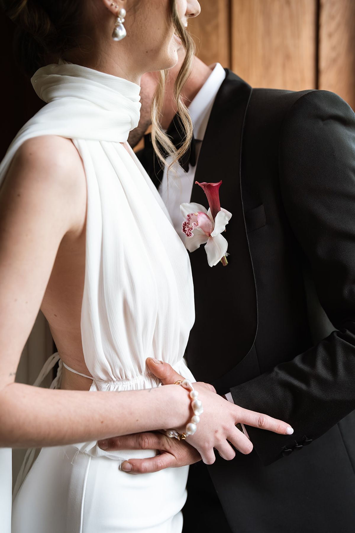 Close-up of the groom holding the bride at the waist, her hand resting on his