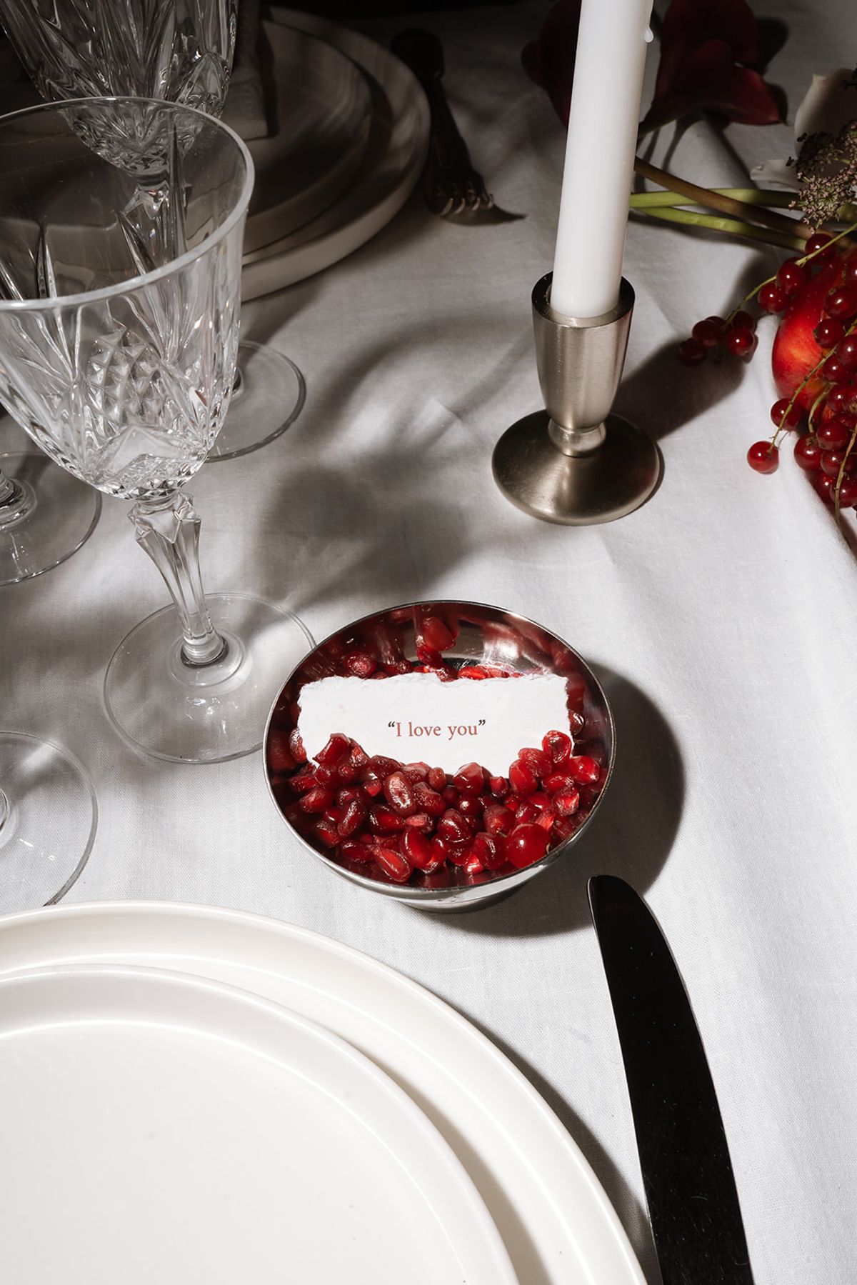 Bowl of pomegranate seeds holding an I love you note on the table