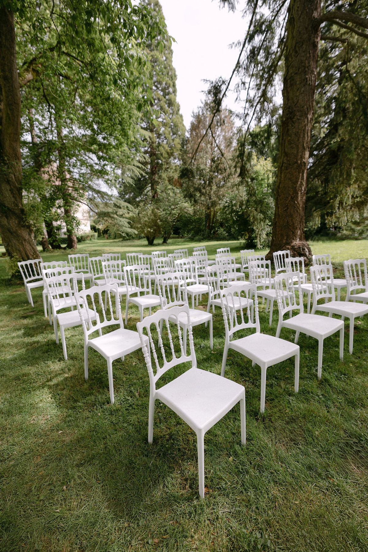 Rows of white ceremony chairs arranged on the lawn, ready for guests.