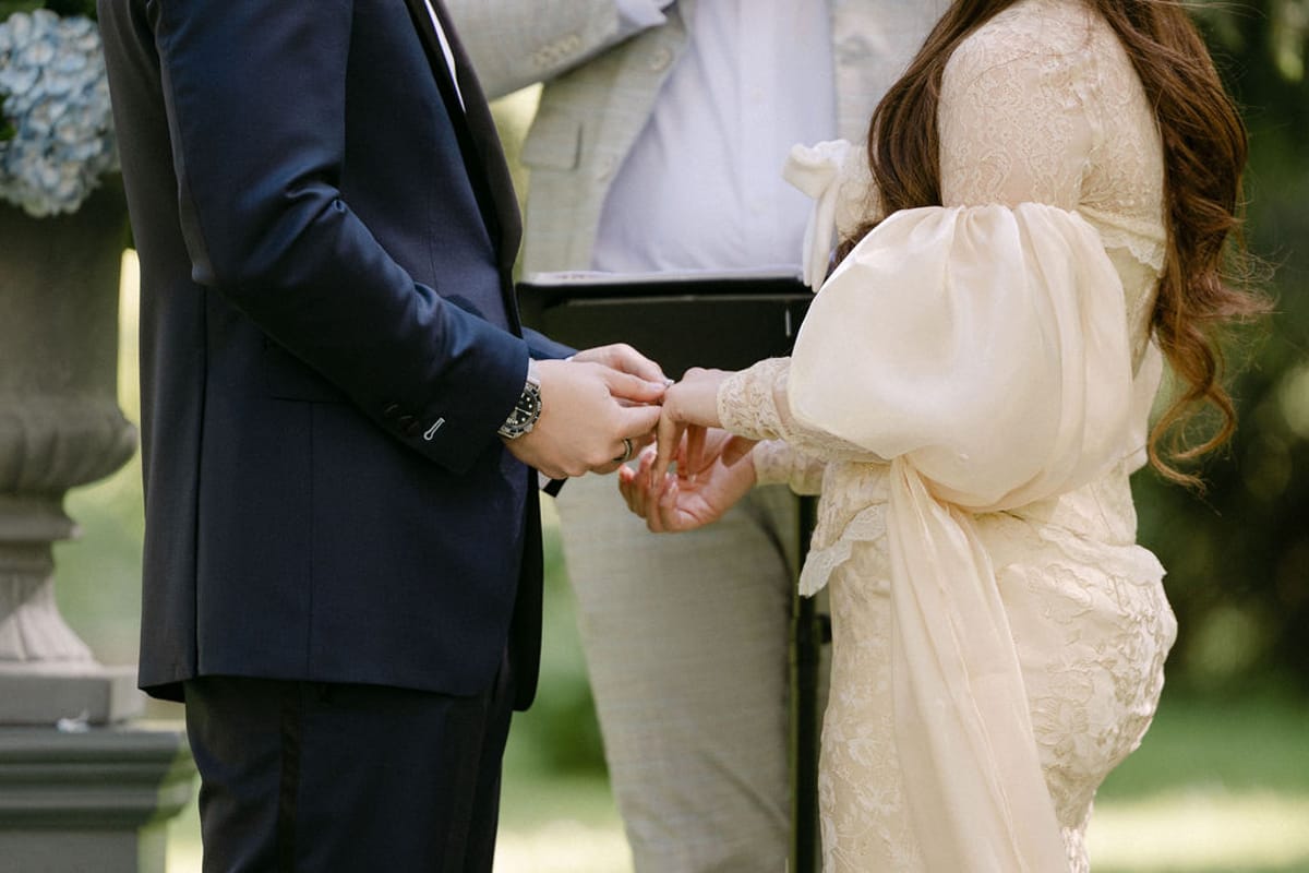 Close-up of Olivia and Jonathan's hands during the ring exchange.