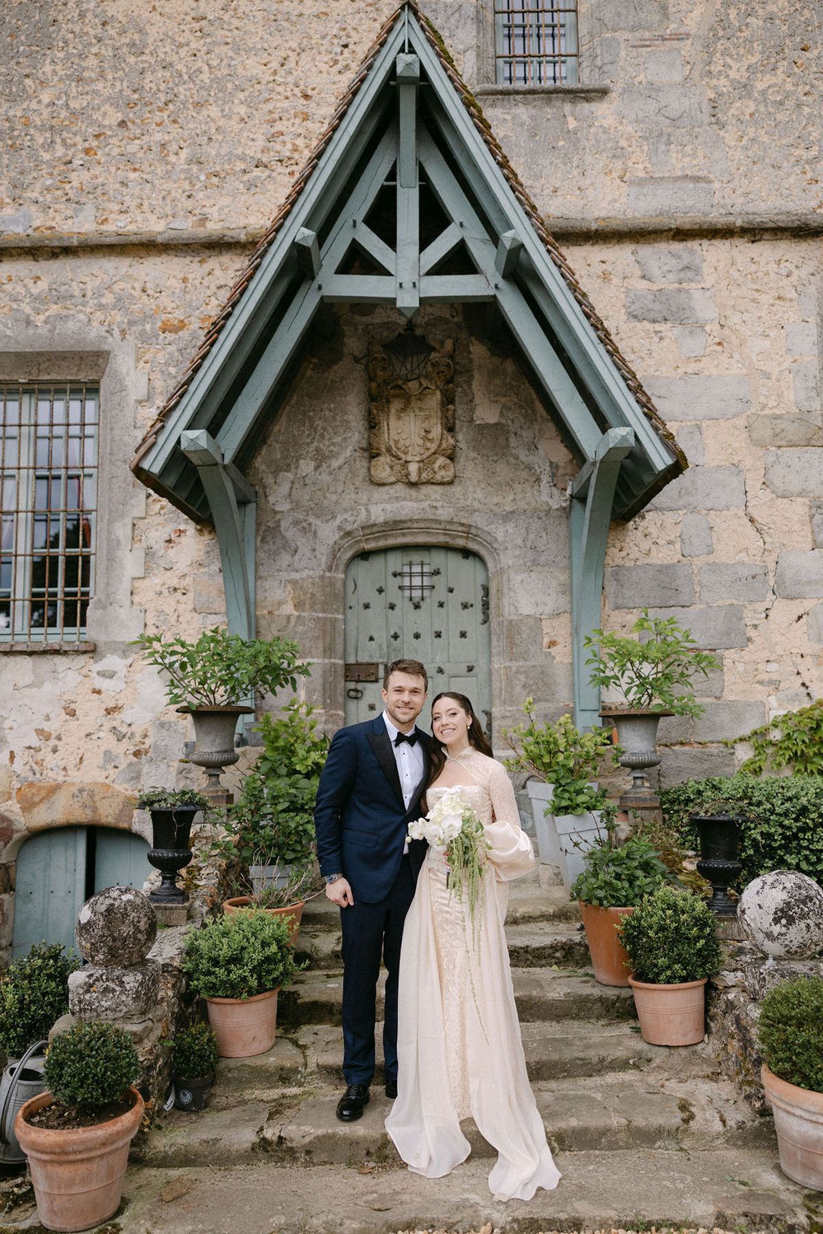 Olivia and Jonathan posed beneath a stone archway at the manor's entrance.