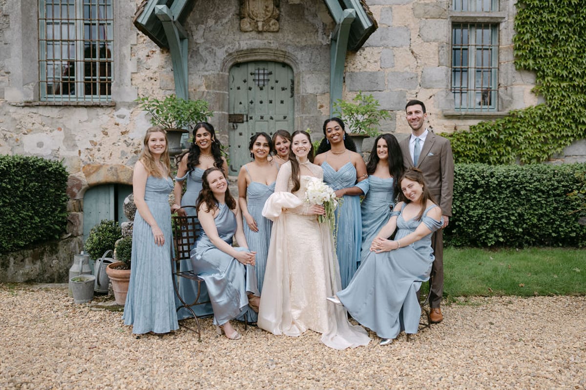 The full bridal party group portrait on the gravel drive at Manoir de Vacheresses.