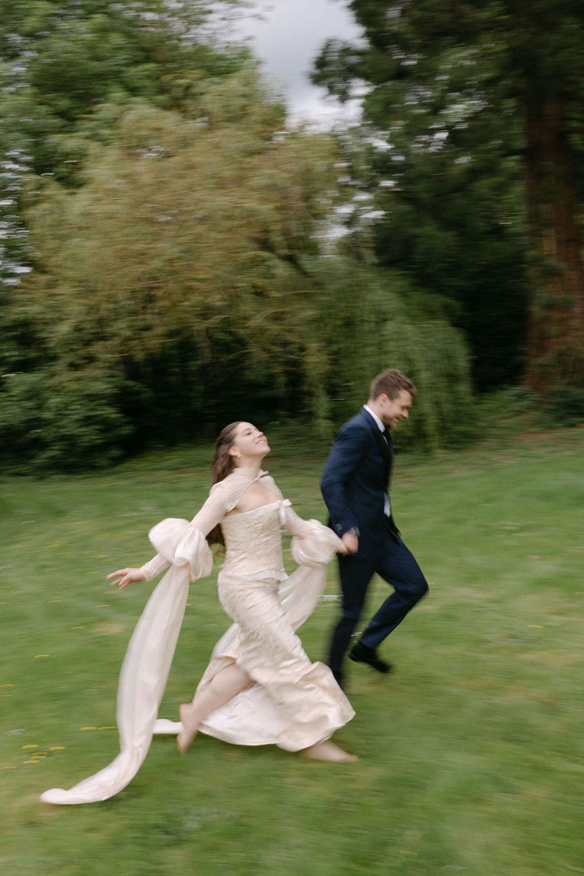 Olivia and Jonathan running together laughing across the lawn.