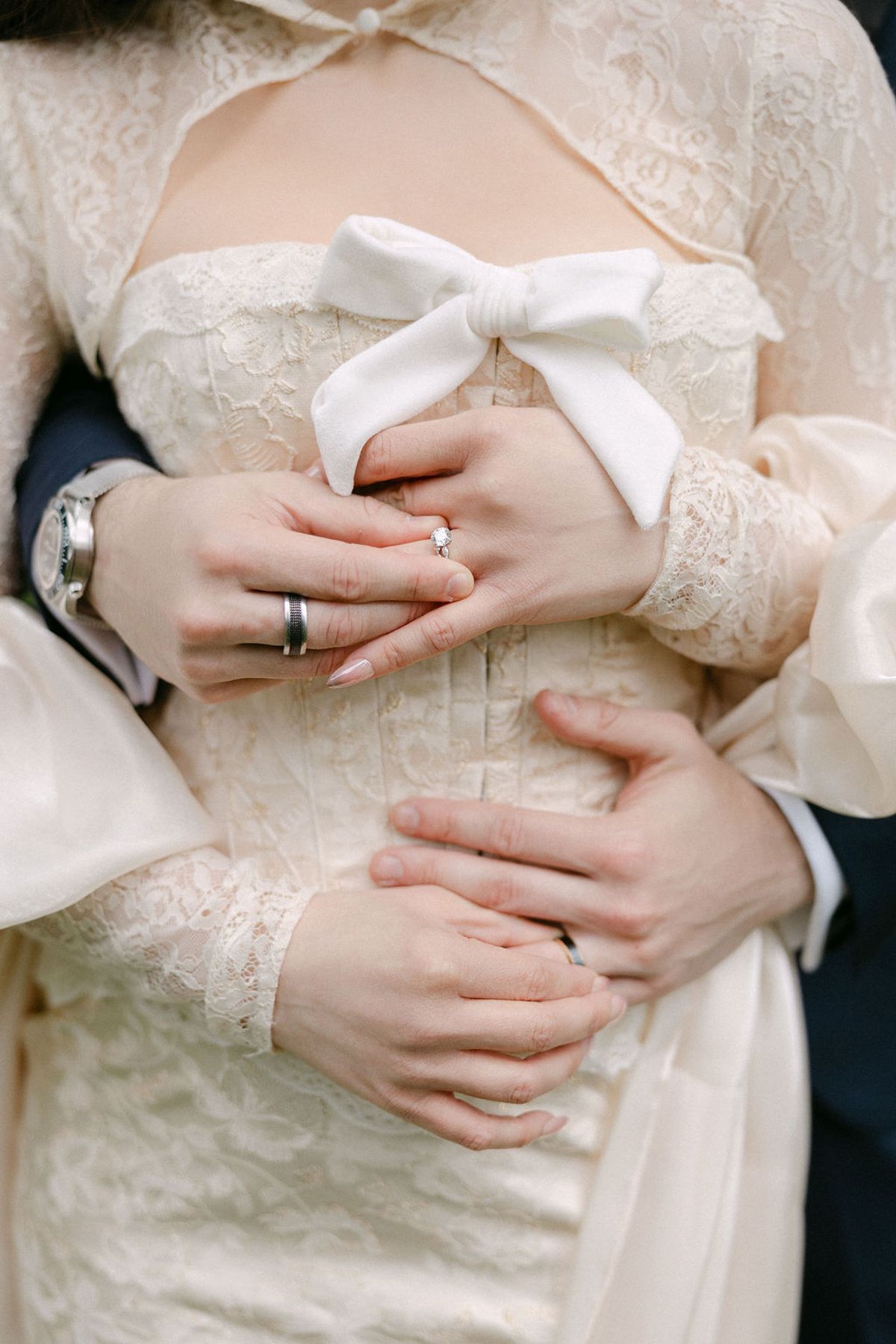 Close-up of Olivia and Jonathan's hands and rings as they embrace.