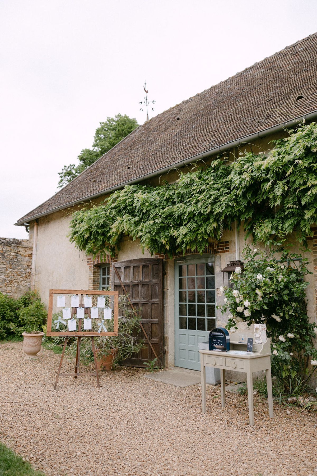 Exterior of a stone outbuilding at Manoir de Vacheresses with a welcome sign.
