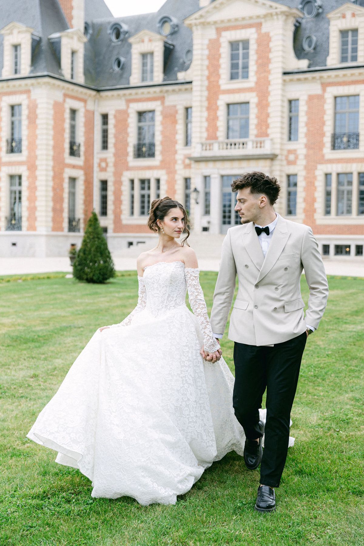 Couple walking across the lawn in front of the chateau