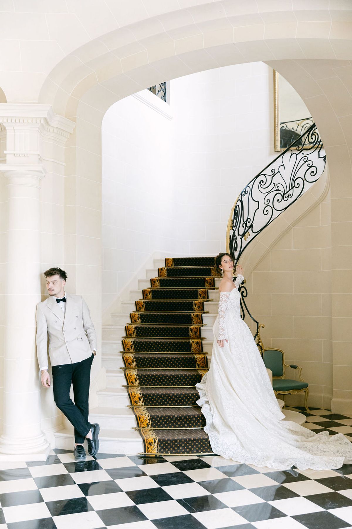 Groom watches the bride descend the chateau staircase