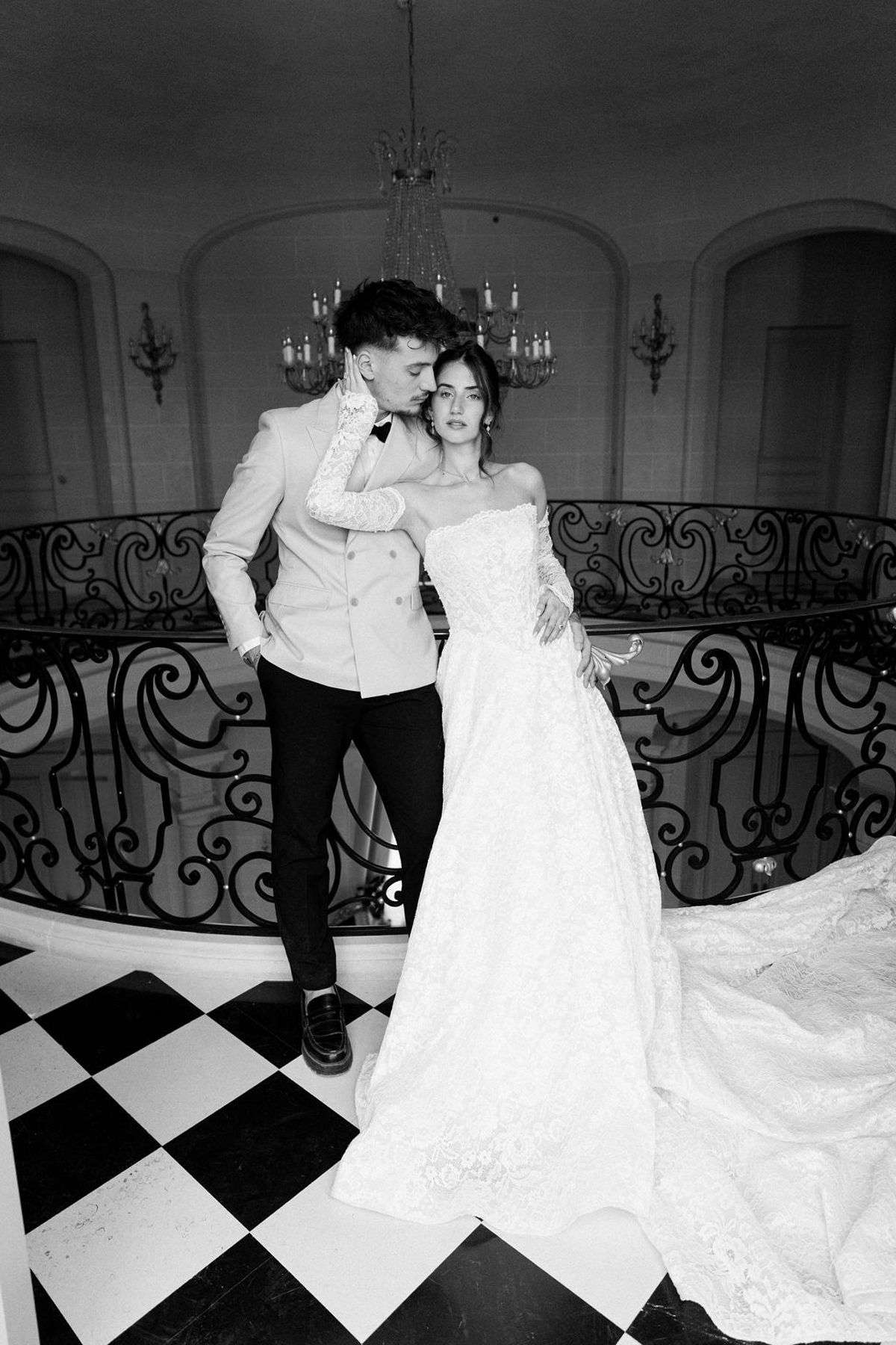 Couple in black and white on the chequerboard floor beneath the staircase