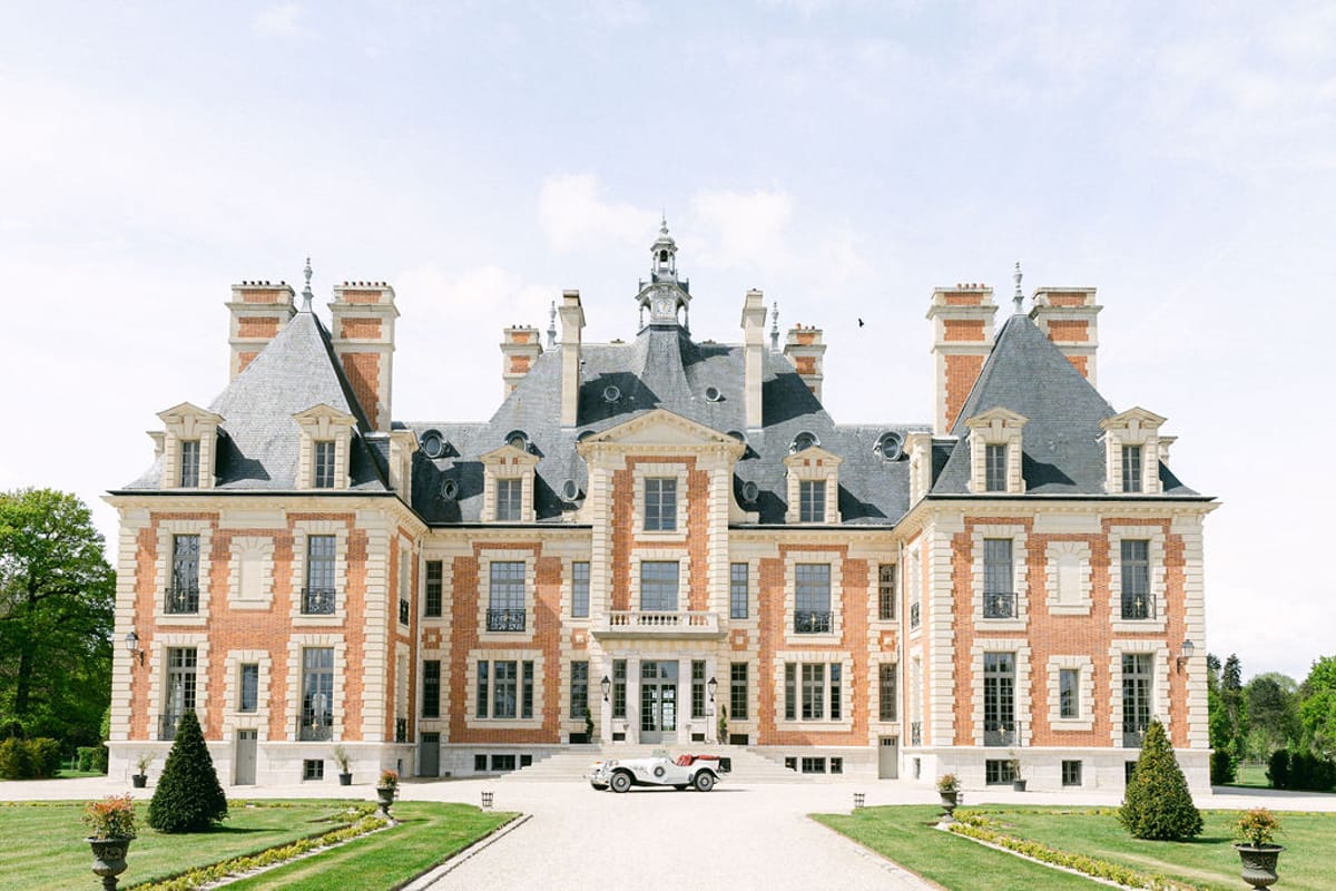 Chateau de Nainville-les-Roches seen head-on with the vintage car at the foot of the steps