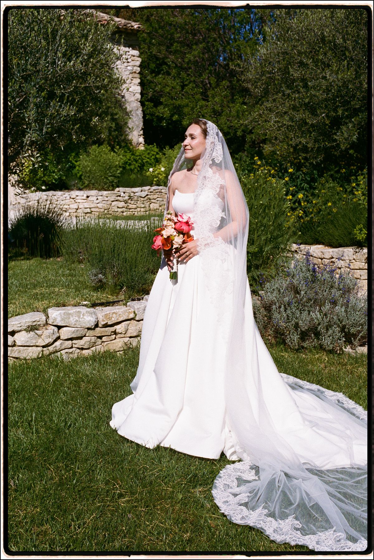 Bride holding her bouquet on a garden path