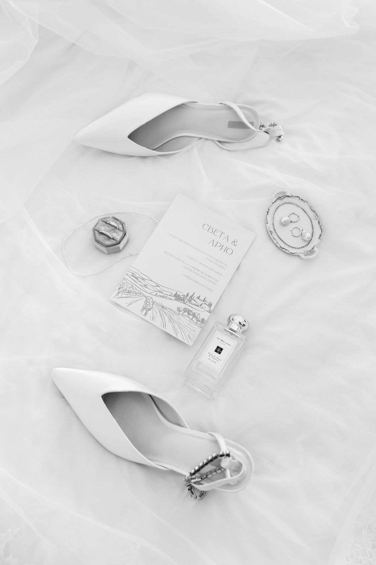 Wedding invitation, perfume bottle and shoes styled as a flat lay