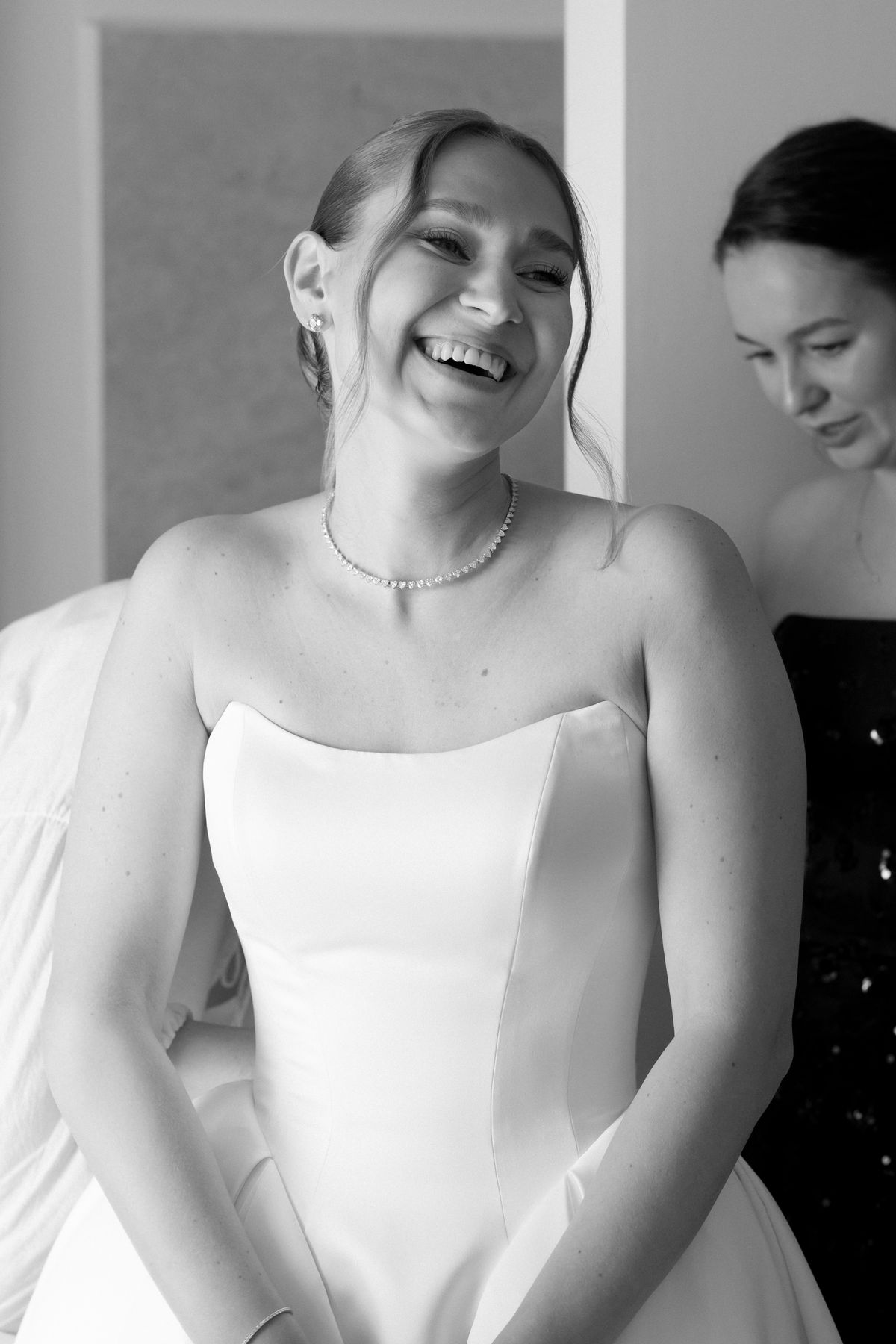 Close-up of the bride's necklace and gown neckline, black and white
