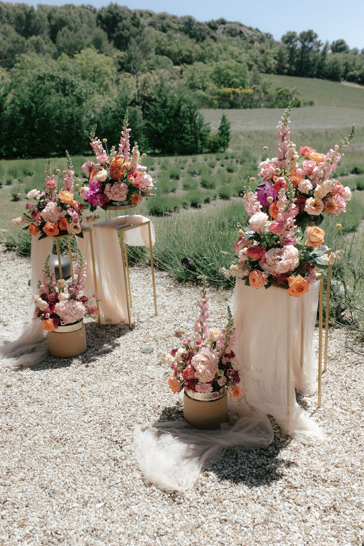 Floral ceremony arrangements flanking the aisle in a lavender field