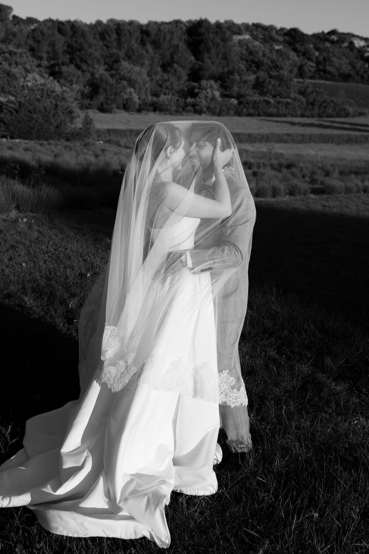 Bride in her wedding gown standing in a Provence field, black and white