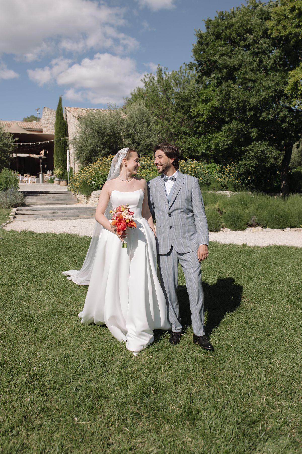 Bride and groom walking together on a stone path, smiling