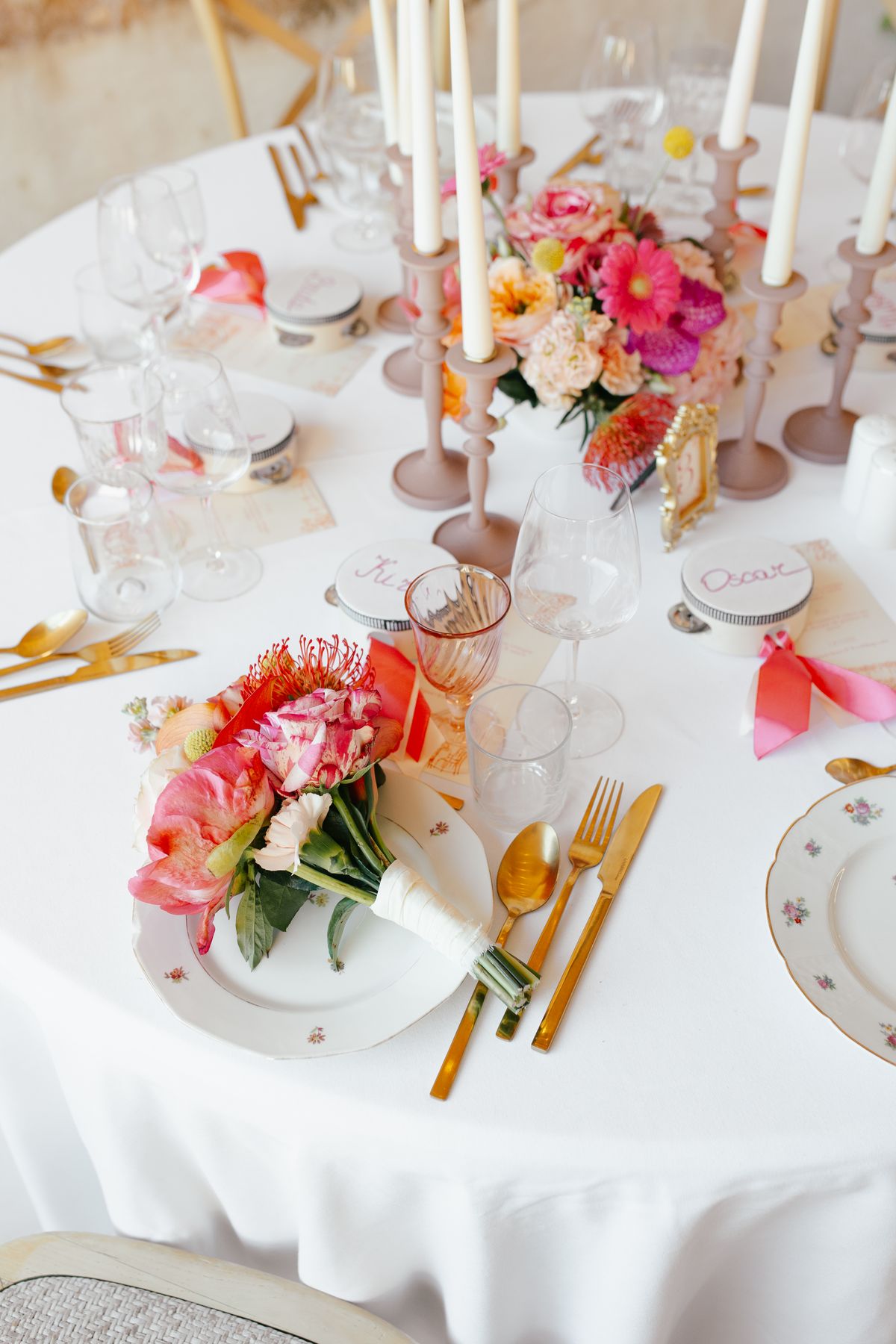 Reception table setting with colourful florals and gold cutlery