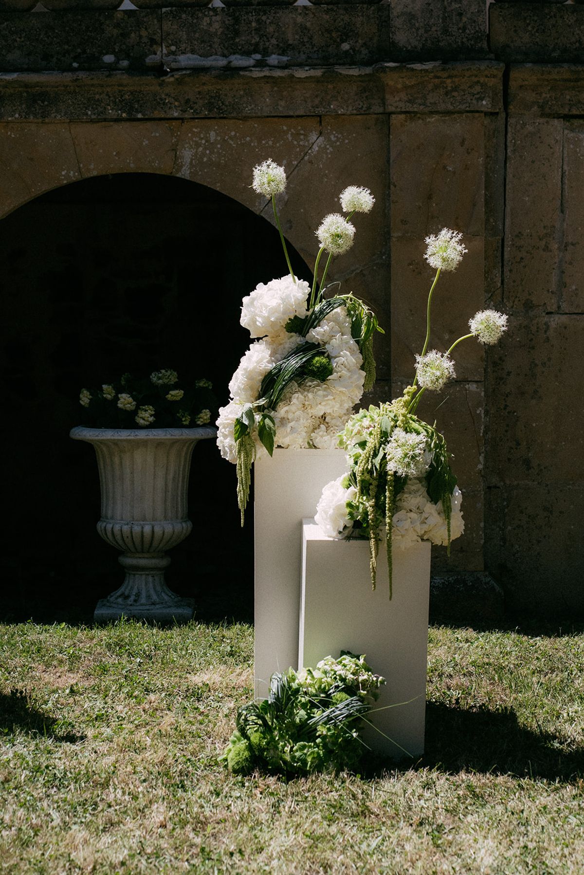 A floral plinth and stone urn in the garden at Chateau du Pont Bourguet