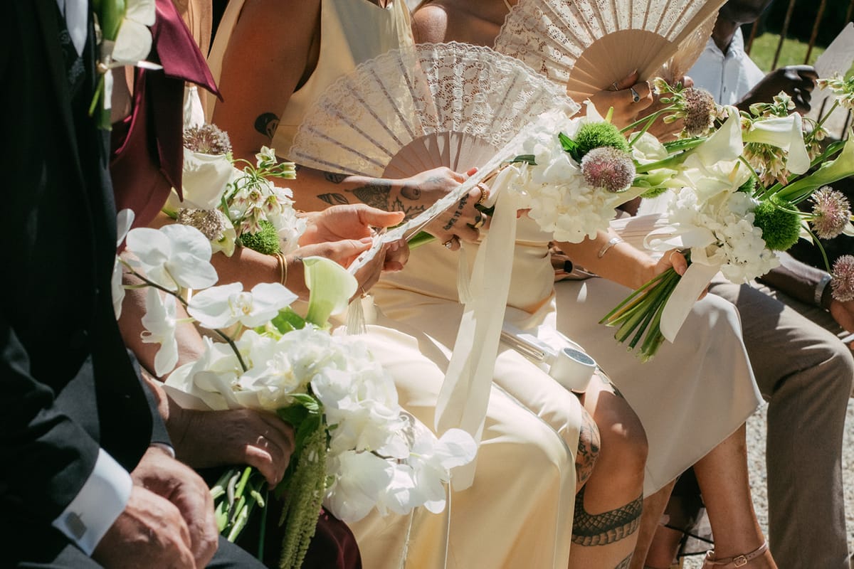 Guests with fans and bouquets during the summer ceremony